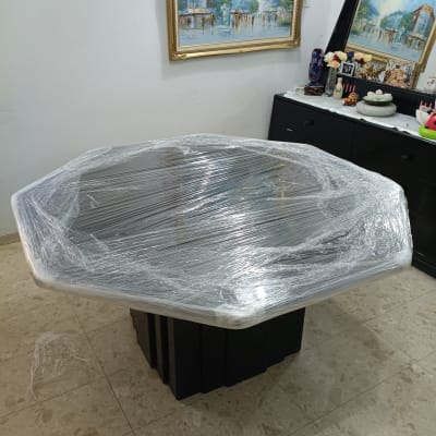 שולחן עטוף בניילון בחדר עם תמונות על הקיר