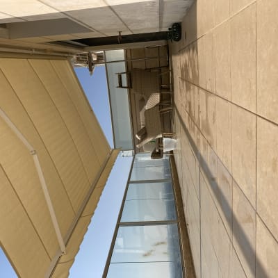 סוכך צהוב פתוח על מרפסת עם רצפת אריחים.