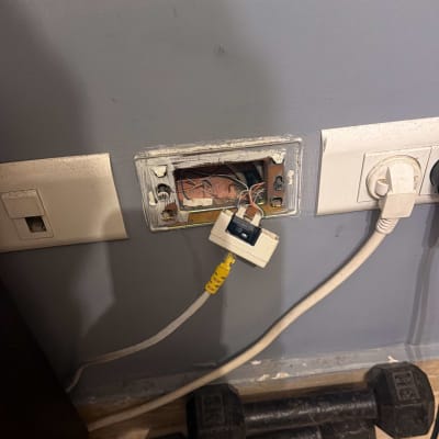 שקע חשמל פתוח עם חוטים חשופים על קיר