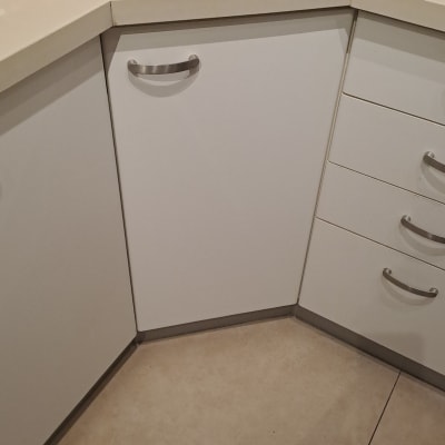 כלי עבודה על משטח מטבח ליד ארונות לבנים