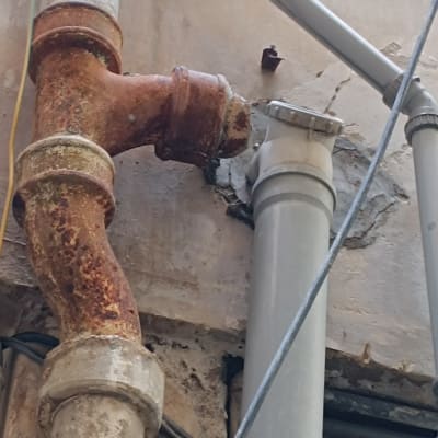 צינורות מתכת חלודים וקירות סדוקים