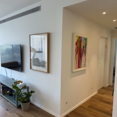 קיר לבן עם יצירות אמנות ותאורה עליונה