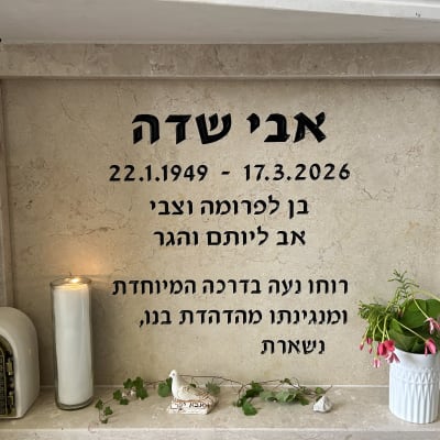 מצבה עם נר זיכרון ופרחים