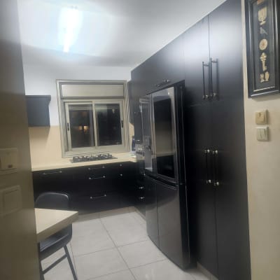 מטבח מודרני עם ארונות כהים ומקרר גדול