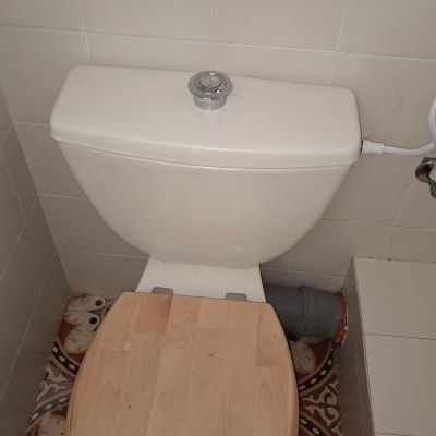 אסלה עם מכסה עץ וצינור מים