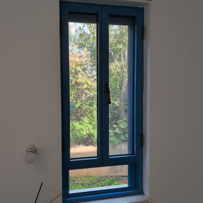 חלון כחול עם נוף עצים בחוץ