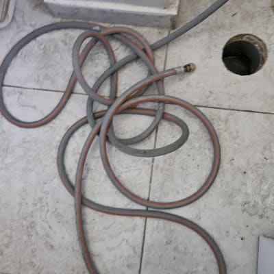 צינור על רצפת אריחים ליד חור בקיר