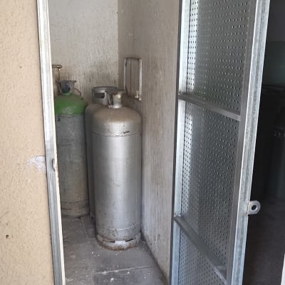 דלת מתכת פתוחה עם בלוני גז מאחוריה