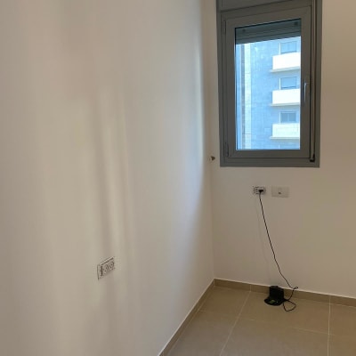 קיר לבן עם שקע חשמל וצללים קלים