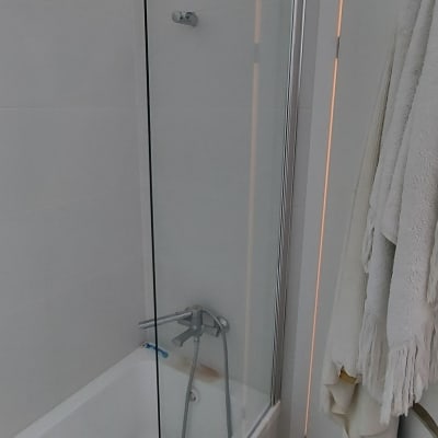 אמבטיה עם דלת זכוכית וברז מקלחת כסוף