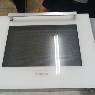 מסך בוש לבן עם ידית מתכת על שולחן