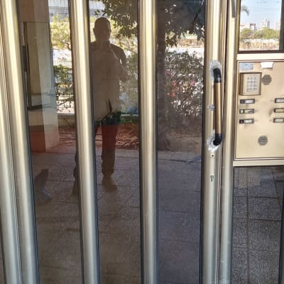 דלת זכוכית עם מסגרת מתכת וידית שבורה