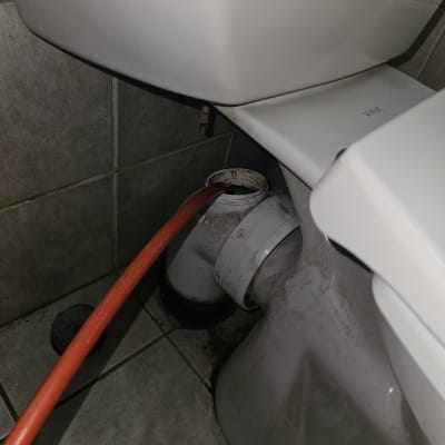 אסלה עם צינור אדום מחובר, עבודה בצנרת
