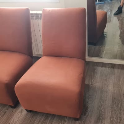 שני כיסאות כתומים בחדר עם רצפת עץ