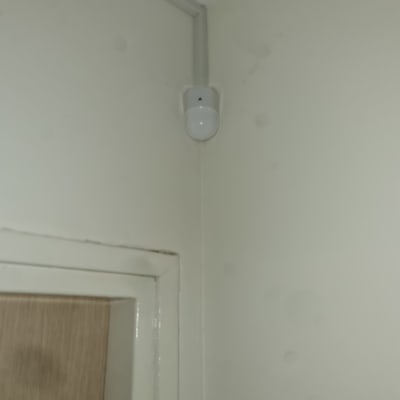 חיישן תנועה מותקן בפינת קיר ליד דלת