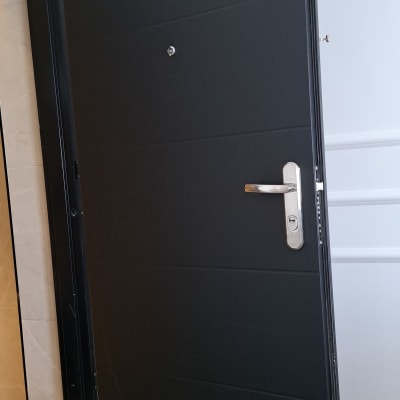דלת שחורה עם ידית כסופה פתוחה למחצה
