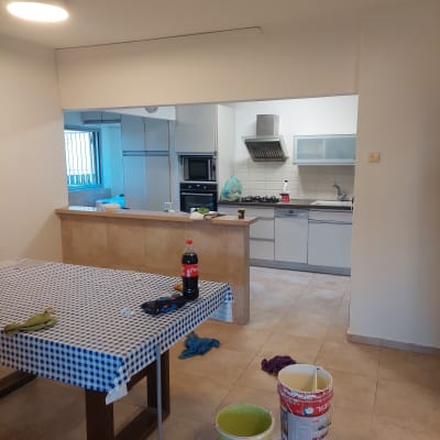 דלי צבע ומברשת על רצפה במטבח