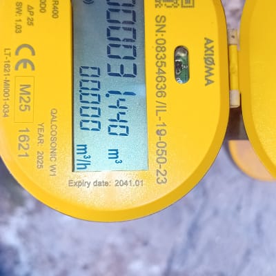 מונה מים דיגיטלי עם תצוגה על רקע קיר בטון