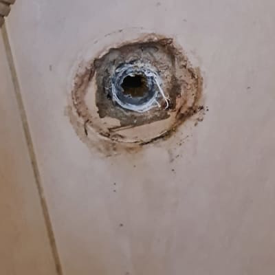 חור בקיר עם צינור פלסטיק חשוף