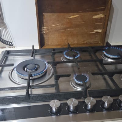 כיריים גז עם להבות כחולות וכלי מטבח