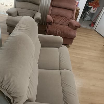 שלושה כורסאות בסלון על רצפת עץ