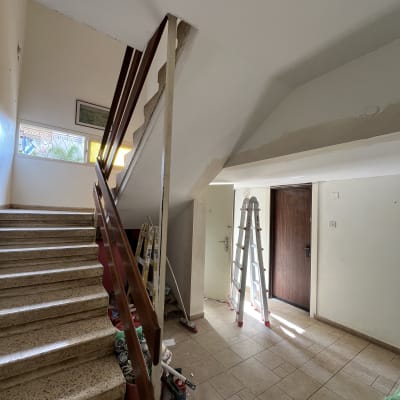 סולם וכלי צבע במסדרון עם קירות צבועים