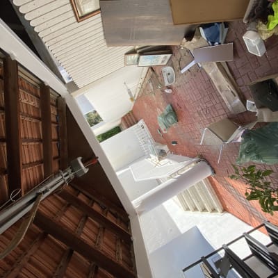 חפצים מפוזרים על רצפה אדומה, שקיות אשפה, כיסא הפוך