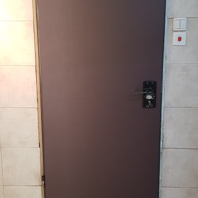 דלת מתכת עם ציפוי כהה ומנגנון סגירה עליון