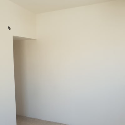 קיר צבוע בלבן עם חור קטן בפינה