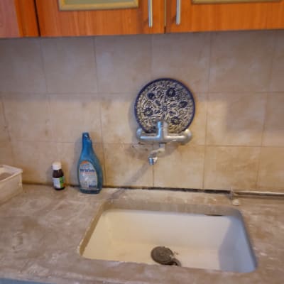 כיור עם ברז, בקבוק חומר ניקוי וכיור מלוכלך