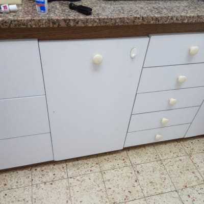 ארון מטבח עם כלים, דבק וכלי עבודה על השיש