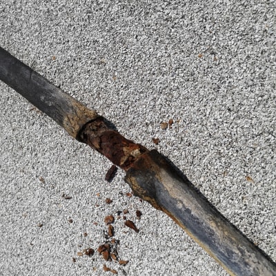 צינור חלוד שבור עם חלודה על הקרקע