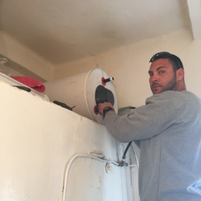 אדם מתקין דוד שמש על קיר פנימי