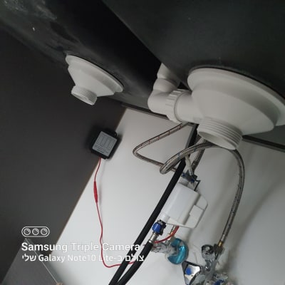 צנרת מתחת לכיור עם מחברים וצינורות מתכת