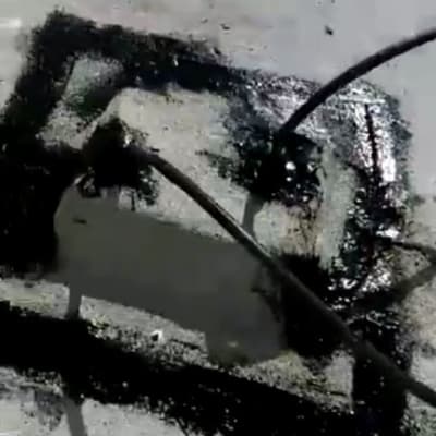 איטום עם חומר שחור על משטח בטון