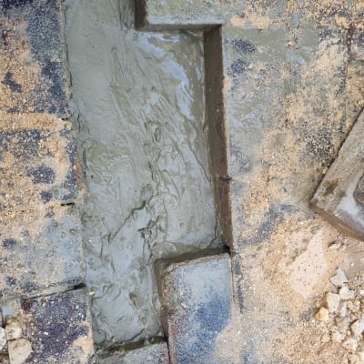 תעלה עם בטון רטוב ואבנים מסביב