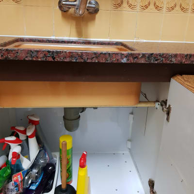 כיור עם ברז, פומפה וכלי ניקוי בארון מתחת