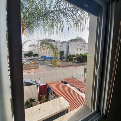 חלון אלומיניום עם מסגרת מתכת נראית מבחוץ