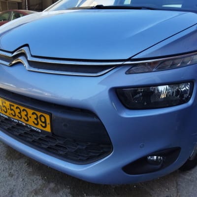 חזית רכב כחול עם פנסי חזית ולוחית רישוי