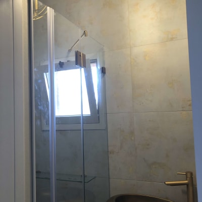 כיור עגול כהה עם ברז זהב בחדר אמבטיה