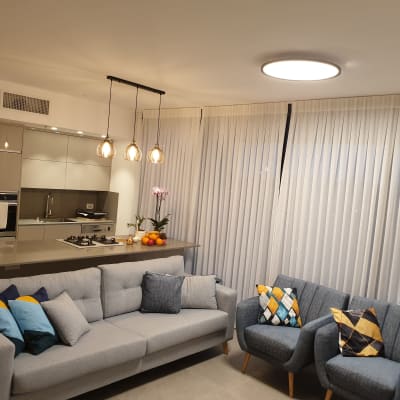 וילונות לבנים תלויים בסלון מודרני מואר