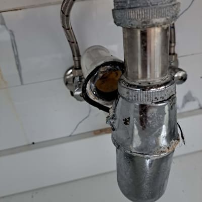 צינור מתכת עם חיבורים מתחת לכיור