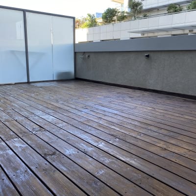 רצפת עץ חיצונית עם מחיצה זכוכית אטומה