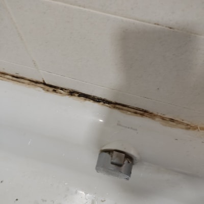 ברז אמבטיה עם כתמי עובש על הקיר