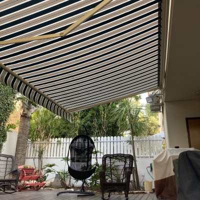 סוכך פסים מותקן מעל מרפסת עץ