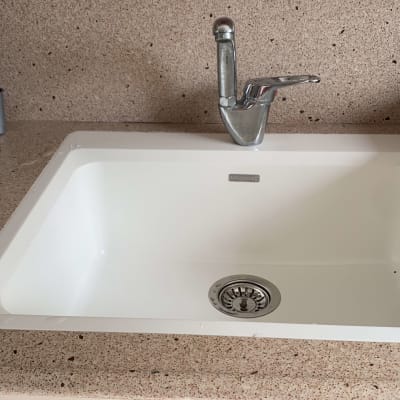 שיש חום מנוקד עם כיור לבן וברז כסוף