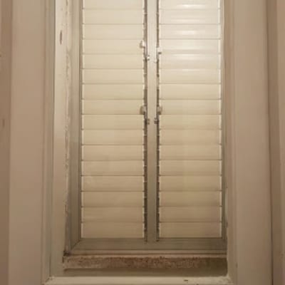 דלת עם חלון זכוכית ותריסים סגורים