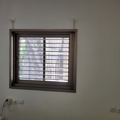 חלון עם תריסי אלומיניום פתוחים למחצה