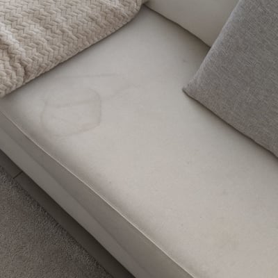 כתם על ספה בהירה עם כריות