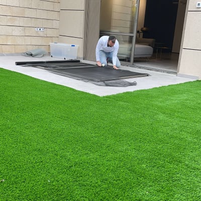 אדם מתקין תריסים ליד דלת זכוכית